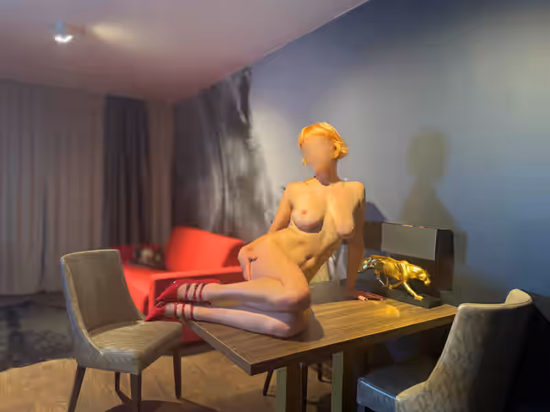 Escort Lady Olivia sitzt nackt auf einem Holztisch, nur rote High Heels schmücken ihren Körper. Mit zurückgelehntem Oberkörper und leicht geöffneten Beinen präsentiert sie selbstbewusst ihre Kurven und ihre nackte Brust. Der goldene Panther neben ihr verstärkt die wilde, animalische Stimmung der Szene. Olivia bei Hot MD Escort Magdeburg zeigt sich hier als verführerische Schönheit, die Lust und Dominanz zugleich ausstrahlt.